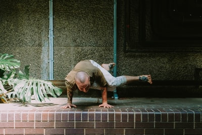 Wearing a white long sleeve shirt and grey trousers woman lying on the gray cement block
